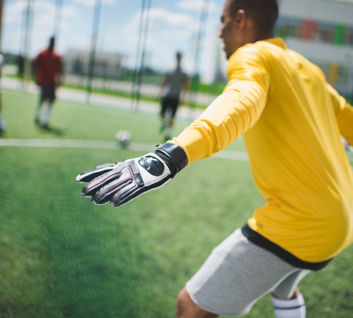 side view of african american goalkeeper standing on soccer pitch
